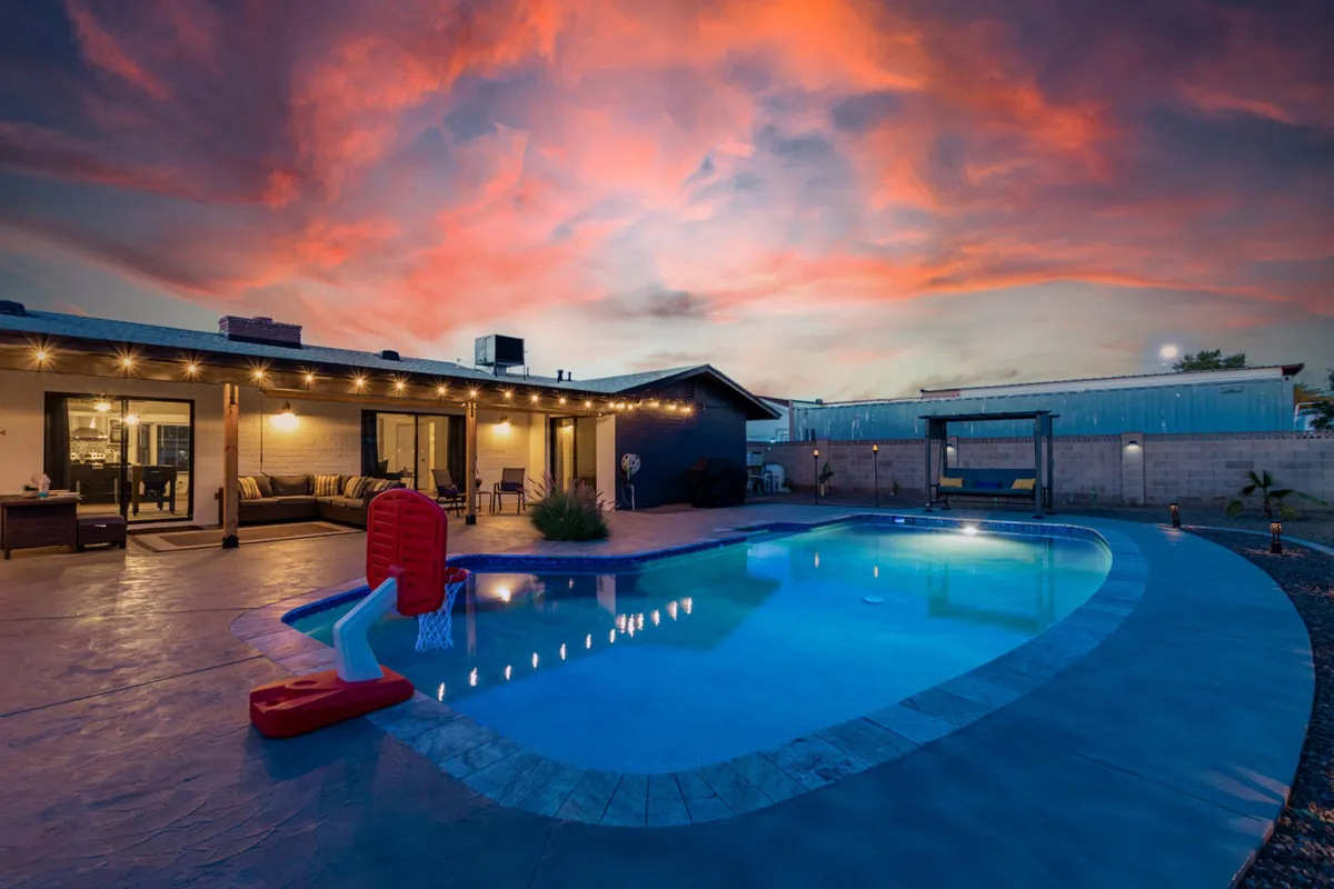 Set in the backyard, this lively scene features a swimming pool, outdoor seating, a basketball hoop, and a colorful sunset sky. The atmosphere is playful and energetic, suggesting both active fun and relaxing gatherings. It captures the essence of backyard celebrations and sporty activities at home.
