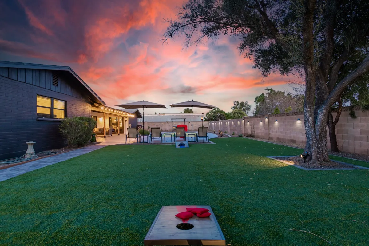 An exterior seating area is arranged around a game set, with a backdrop of a cheerful sunset sky. The space is clearly designed for entertaining and playing games, echoing the friendly, family-focused atmosphere described in the section.