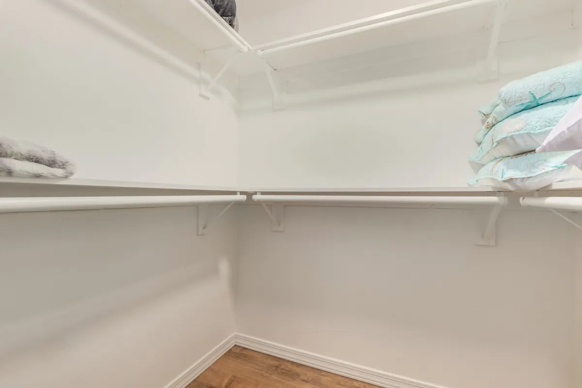 A set of tidy shelves stacked with plush, folded linens, creating a sense of cleanliness and abundance. The scene evokes an organized and well-prepared home.